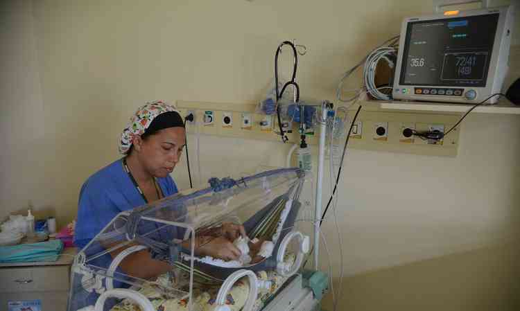 Enfermeira cuidado de beb em incubadora
