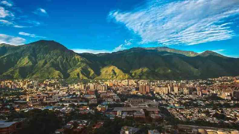 Paisagem ampla de Caracas, com montanhas ao fundo e dia ensolarado