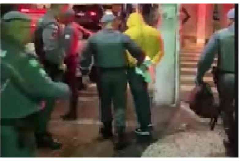 homem de casaco amarelo sendo levado pela polcia militar