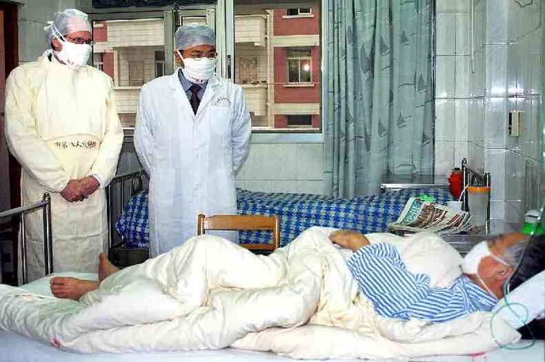 Robert Maguire, da OMS, e mdico chins visitam paciente com Sars em Guangzhou em abril de 2003: houve crticas em relao  transparncia das autoridades chinesas durante a epidemia(foto: AFP)