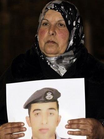 Mãe do piloto da força aérea jordaniana Maaz al- Kassasbeh, segura foto do filho durante protesto em janeiro(foto: AFP PHOTO / KHALIL MAZRAAWI ) Mãe do piloto da força aérea jordaniana Maaz al- Kassasbeh, segura foto do filho durante protesto em janeiro(foto: AFP PHOTO / KHALIL MAZRAAWI )