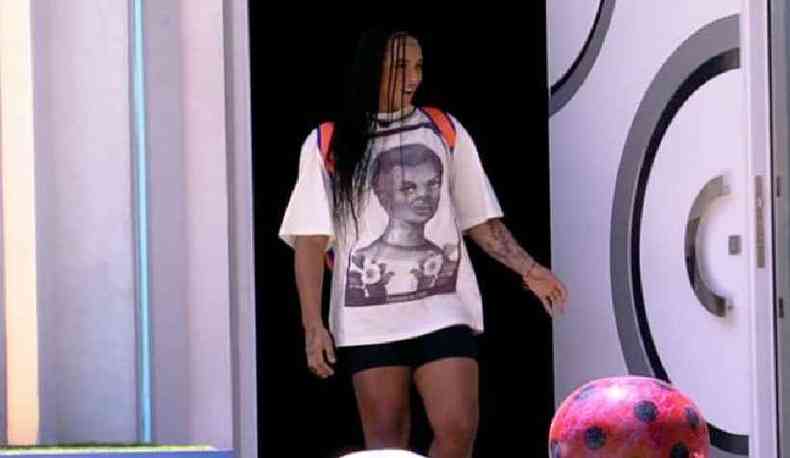 Linn da Quebrada usando uma camiseta de 'Anastácia Livre' entrando na casa do Big Brother Brasil