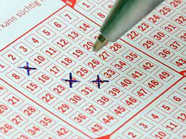 Na imagem h um bilhete de loteria e uma caneta para marcar as apostas 