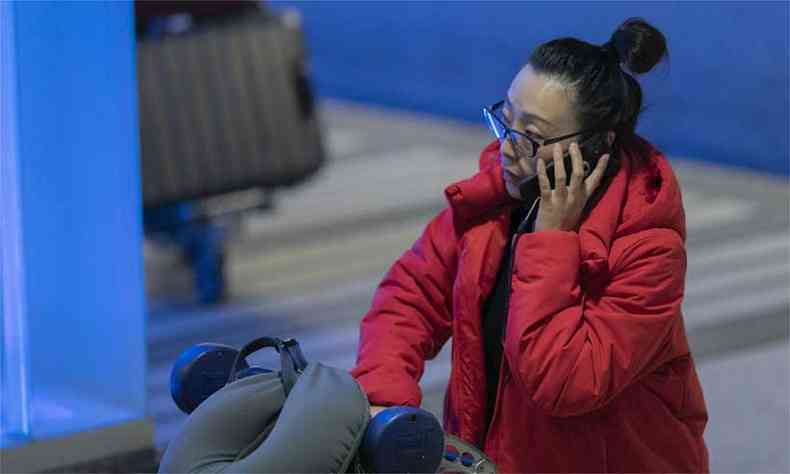 Passageira chega ao Aeroporto Internacional de Los Angeles após o pouso de um voo da Air China de Pequim(foto: DAVID MCNEW /AFP )