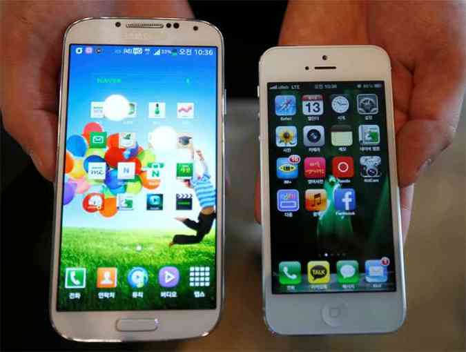 Vendedor mostra a diferena de tamanho entre um Galaxy S4 ( esquerda) e um iPhone 5 (foto: REUTERS/Kim Hong-Ji )