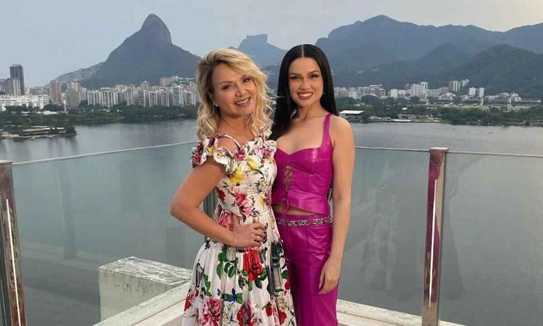 A ex-BBB Juliette e a apresentadora Eliana esto sentadas no terrao de cobertura, sorrindo para a cmera. Ao fundo se v o Pico dos Dois Irmos e a Pedra da Gvea, no Rio