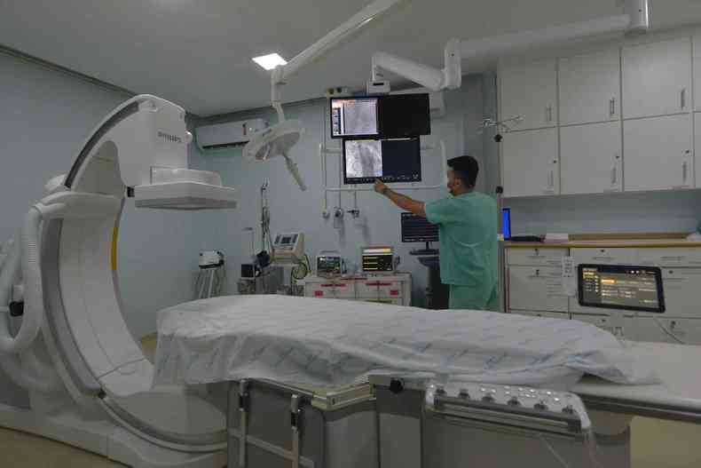 Quarto de hospital com enfermeiro manuseando equipamento