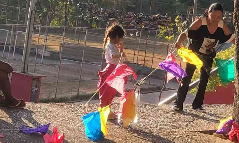 Criança ajudando a segurar bandeirinhas de festa junina