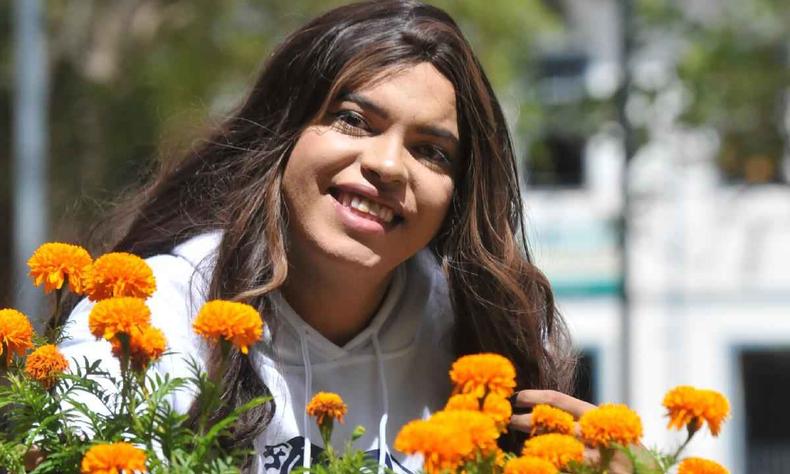 Spencer Spencer, posando ao ar livre com flores amarelas