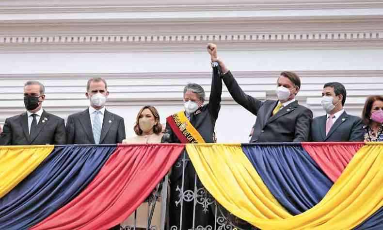 Com proteo facial, Bolsonaro participou da posse do presidente do Equador, Guillermo Lasso, de quem levantou o brao(foto: Rodrigo Buendia/AFP)