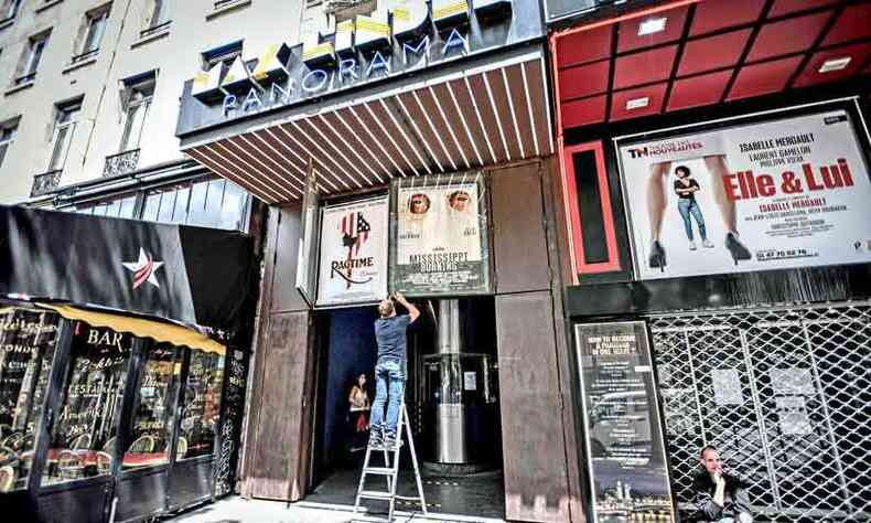 Empregados de cinema de Paris removem cartazes de filmes. Salas foram fechadas na quarentena (foto: Stephane de Sakutin/AFP)
