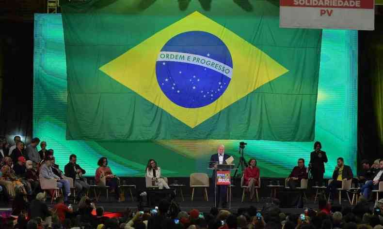 Lula, lderes partidrios e uma grande bandeira do Brasil em palanque em So Paulo