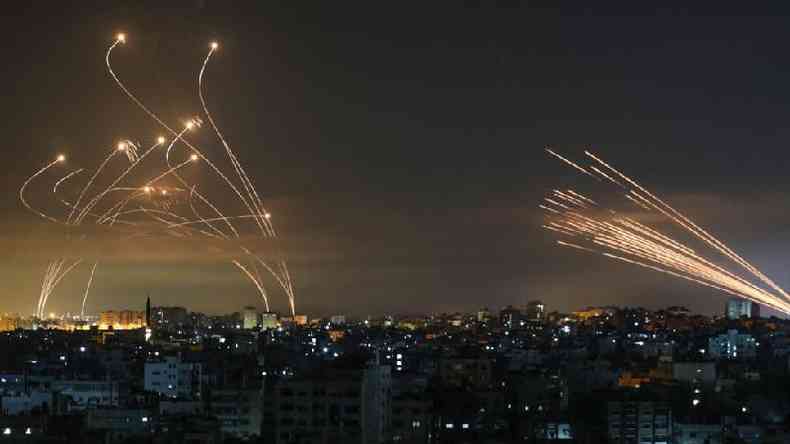 Os msseis israelenses,  esquerda, lanados para interceptar os foguetes do Hamas,  direita(foto: ANAS BABA/Getty Images)