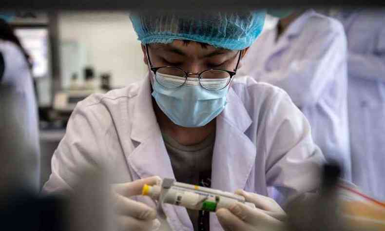 Funcionrio do Beijing Applied Biological Technologies (XABT), na China, trabalha em desenvolvimento de vacina contra coronavrus(foto: NICOLAS ASFOURI / AFP)