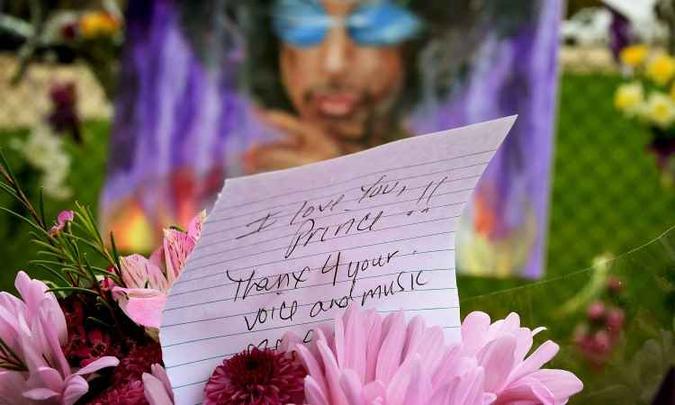 Fãs deixam homenagens ao cantor em frente ao Paisley Park, em Minneapolis(foto: AFP / Mark Ralston ) Fãs deixam homenagens ao cantor em frente ao Paisley Park, em Minneapolis(foto: AFP / Mark Ralston )