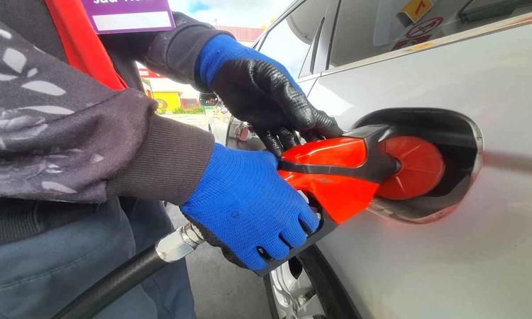 Frentista abastecendo carro em um posto de gasolina de BH 