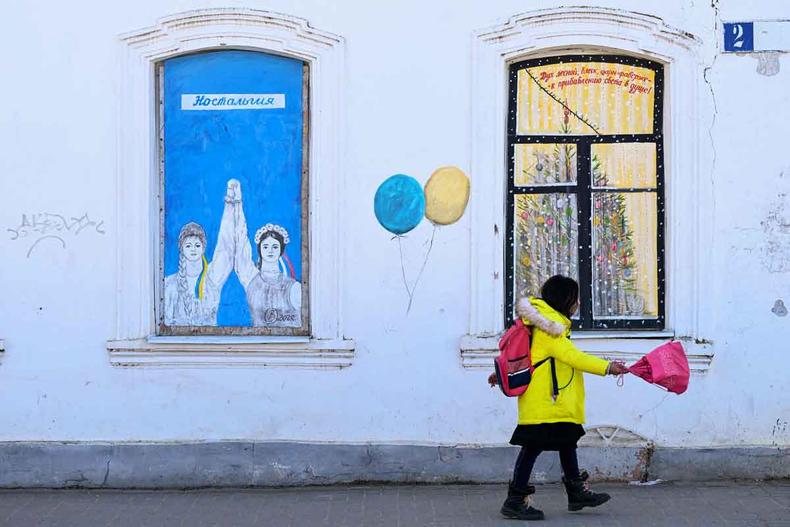 Grafite de Vladimir Ovchinniko tem duas mulheres de mos dadas. Uma traz faixa nos cabelos com as cores da Rssia, outra tem faixa com cores da Ucrnia