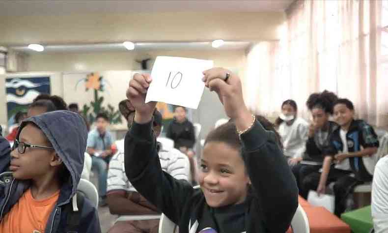 Sala de aula com crianas dando notas para apresentaes de Slam em pedaos de papel