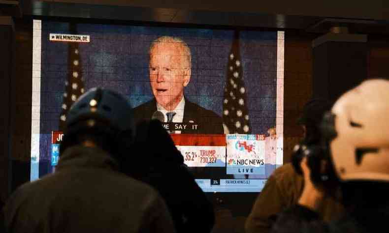 Americanos assistem a pronunciamento de Joe Biden pela TV(foto: Eze Amos / GETTY IMAGES NORTH AMERICA / Getty Images via AFP)