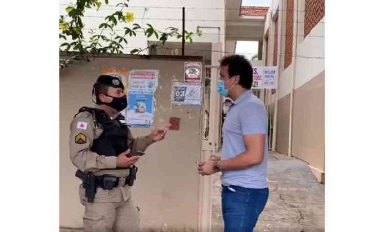 Policial militar conversa com o vereador na porta da escola