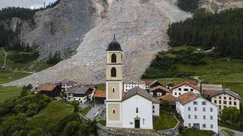 Vilarejo, incluindo igreja, com rea de deslizamento atrs