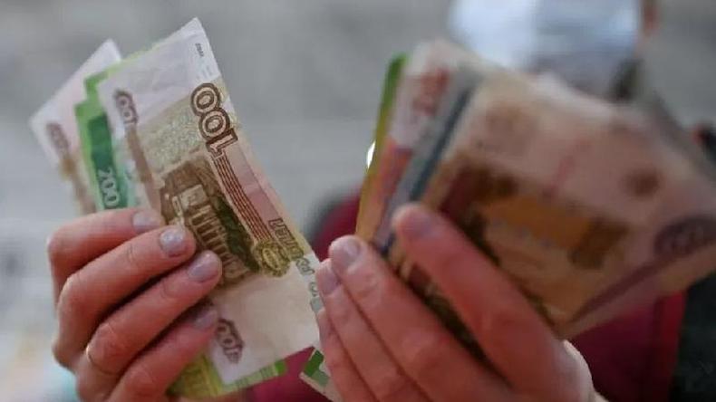 As sanções que têm sido aplicadas á Rússia têm o objetivo levar a economia do país à recessão, frisam especialistas(foto: Reuters) Pessoa segurando notas do rublo, o dinheiro russo