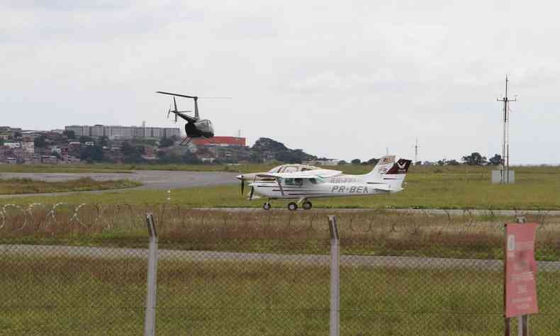Avio e helicptero em pista do aeroporto Carlos Prates