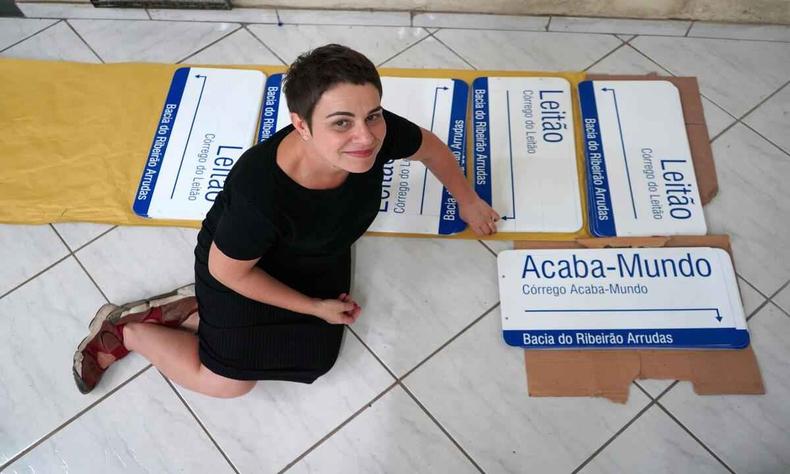 Artista Isabela Prado com placas de sua intervenção artística que resgata nome dos córregos canalizados de BH(foto: Aline Xavier/Divulgação) Memória urbana