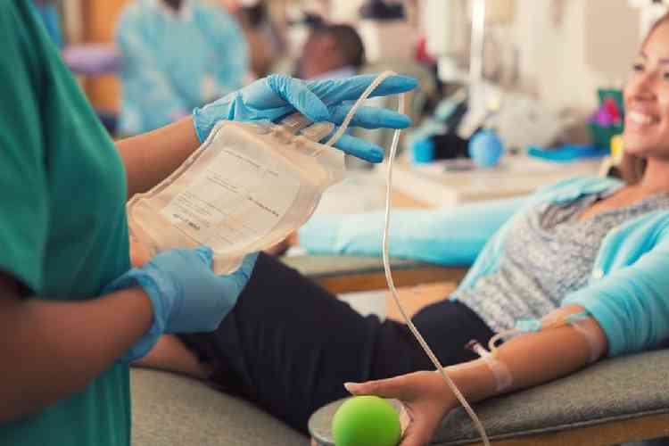 Mulher doando sangue no hemocentro