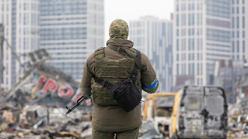 Soldado com metralhadora perto do centro comercial destrudo de Retroville aps bombardeio russo
