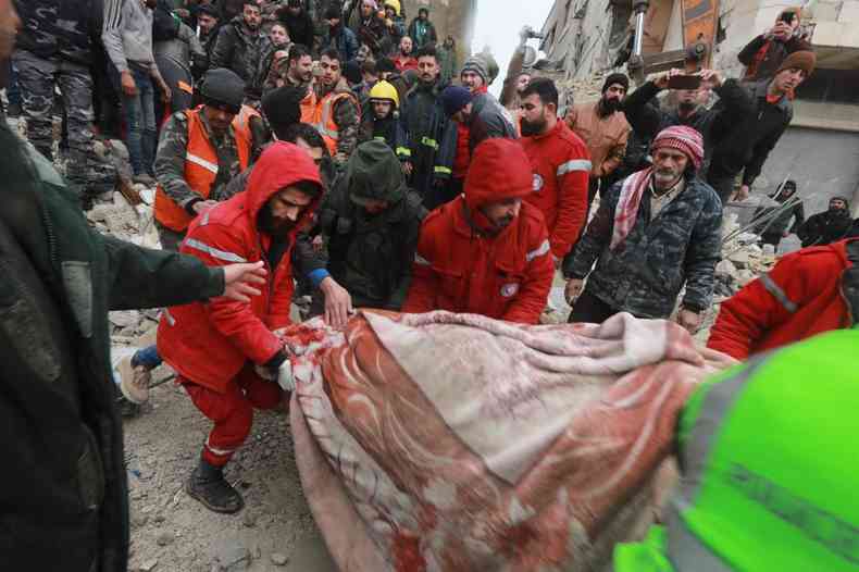 voluntrios carregam corpos encontrados nos escombros