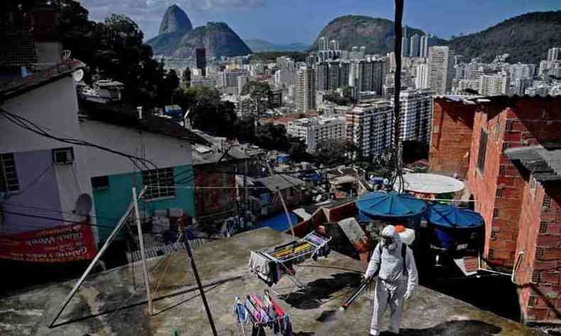 Funcionrio da Prefeitura do Rio faz desinfeco no Morro Santa Marta: populao mais pobre foi a mais afetada no Brasil(foto: CARL DE SOUZA/AFP)