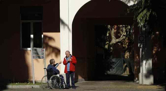 Homem em cadeira de rodas em frente  Fundao Sagrada Famlia, instituio que Berlusconi far trabalho comunitrio(foto: Alessandro Garofalo/Reuters)