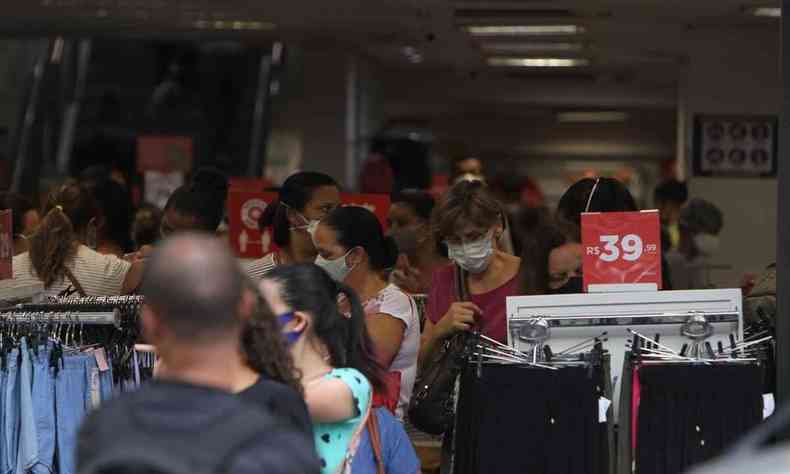 Loja de roupas no Centro de Belo Horizonte com araras de roupas e dezenas de clientes.