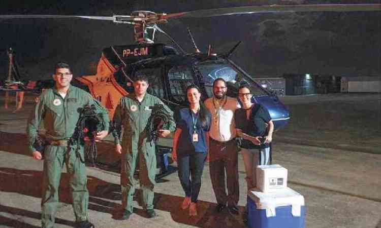 Equipe de transplante do Felcio Rocho e do Comando de Aviao do Estado juntas, dento helicptero ao fundo e, na frente, recipiente para os rgos