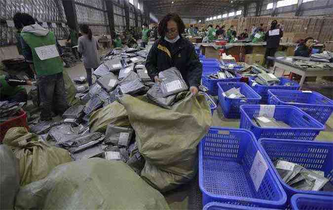 Funcionrios separam pacotes em centro de servio de entrega expressa na China. No Brasil, encomendas de pases asiticos subiram 100% no ano passado(foto: REUTERS/Stringer/Files )