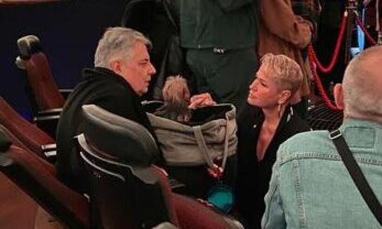 Xuxa ajoelhada em frente ao Roberto de Carvalho; a cachorrinha est em uma sacola entre os dois 