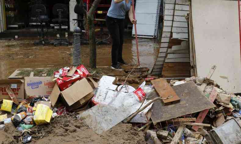 Pessoa limpando os escombros da tragdia em Petrpolis
