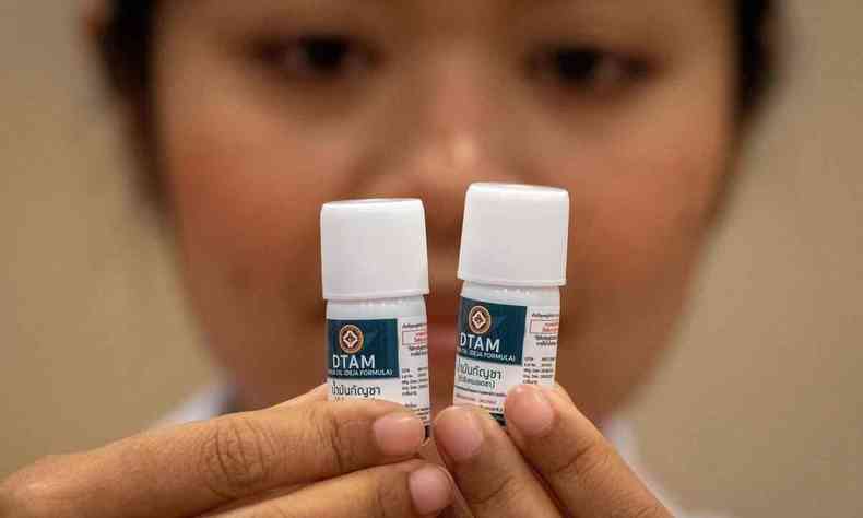 Enfermeira segura dois frascos de medicamentos tailandeses  base de canabidiol 