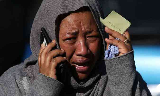 Mulher chora enquanto tenta localizar um parente desaparecido no incndio que engoliu a Grenfell Tower, no oeste de Londres(foto: Daniel LEAL-OLIVAS / AFP)