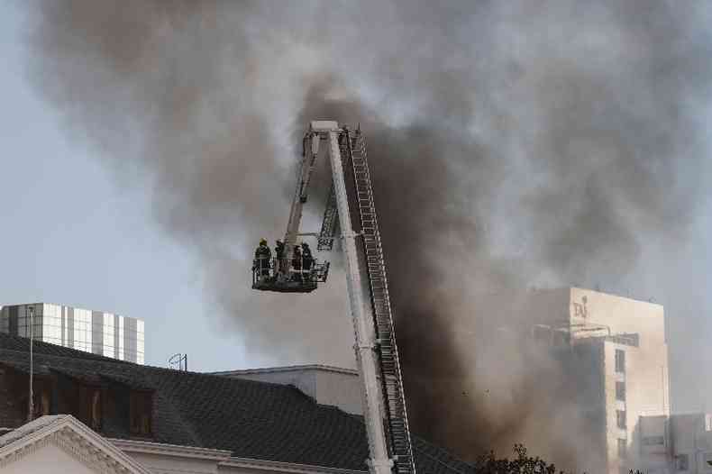 Bombeiros do alto da escada Magirus tentam controlar o fogo