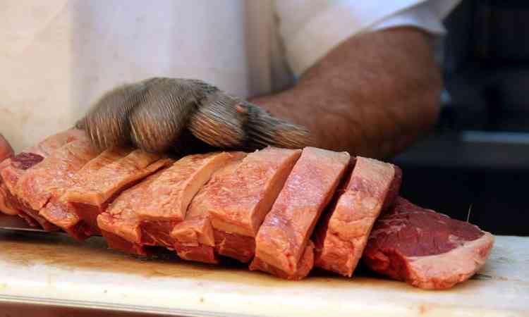 Aougueiro cortando pea de carne 