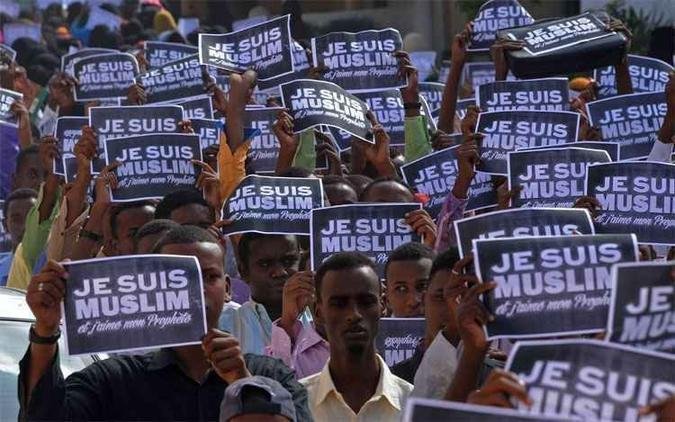 Manifestantes somalis cantam slogans segurando cartazes com os dizeres 