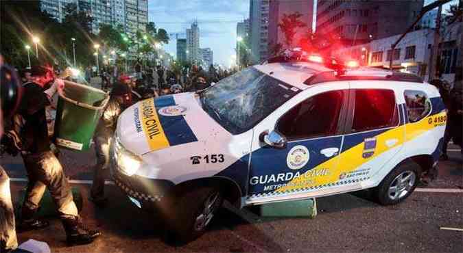 Manifestantes tentam virar carro da Guarda Civil Municipal (foto: AFP PHOTO / Miguel SCHINCARIOL )