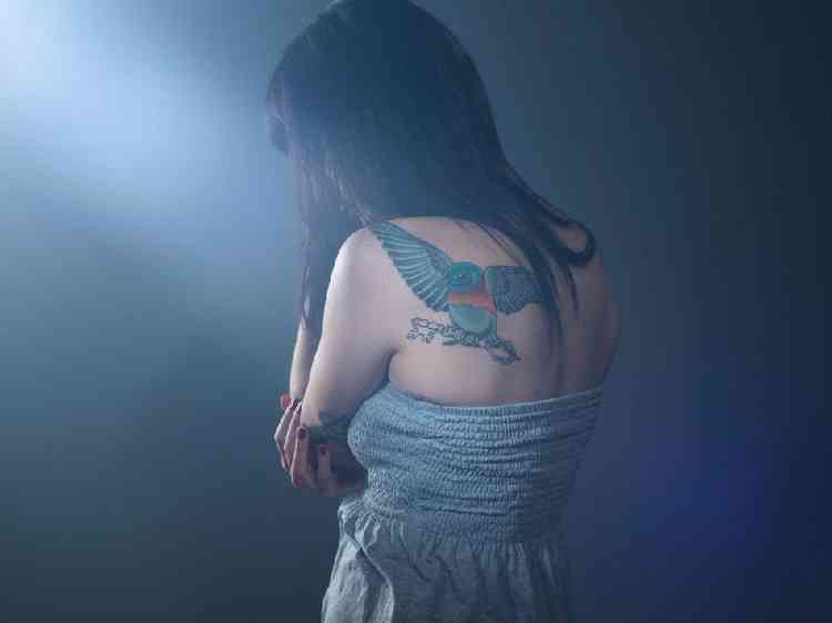 Mulher com as costas tatuadas