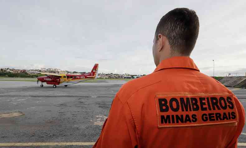 Na foto, imagem ilustrativa de Bombeiro de Minas Gerai olhando um avio da corporao