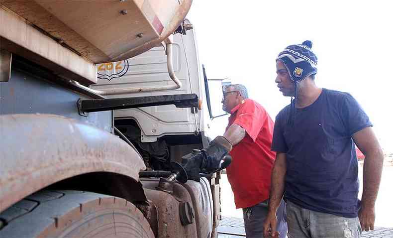 Frentista de posto de combustível coloca óleo diesel em caminhão