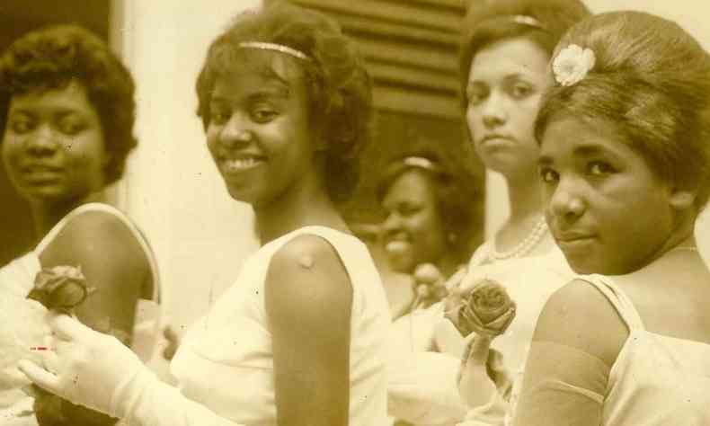Debutantes negras sorriem, segurando rosas, no baile de 15 anos realizado em BH nos anos 1960