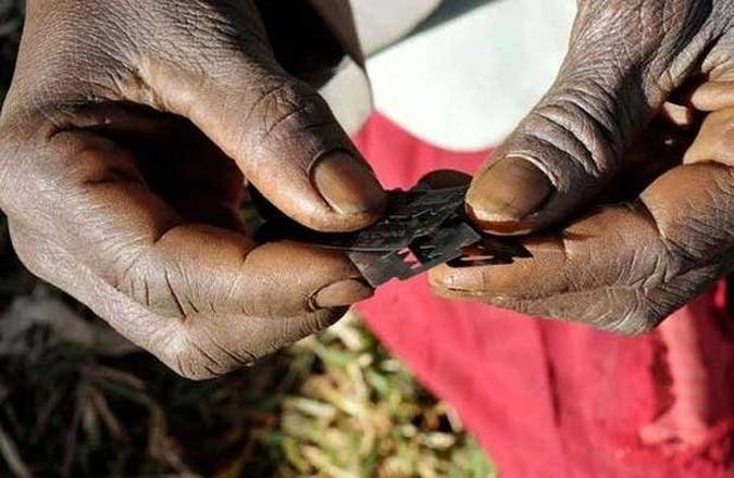 Cirurgiã tradicional segura lâminas usadas para ritual tradicional em adolescentes em tribo de Uganda (foto: James Akena/REUTERS - 15/12/08) Cirurgiã tradicional segura lâminas usadas para ritual tradicional em adolescentes em tribo de Uganda (foto: James Akena/REUTERS - 15/12/08)
