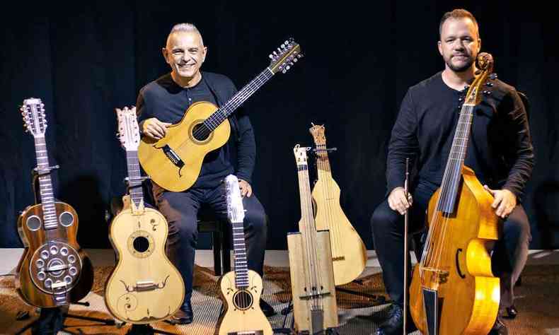 Os msicos Roberto Corra e Gustavo Freccia sorriem, enquanto seguram violas. No cho h cinco exemplares do instrumento
